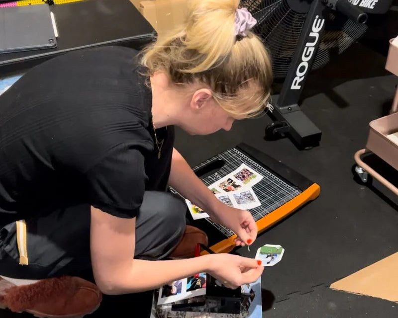Alesia cutting photo magnets in her home workspace